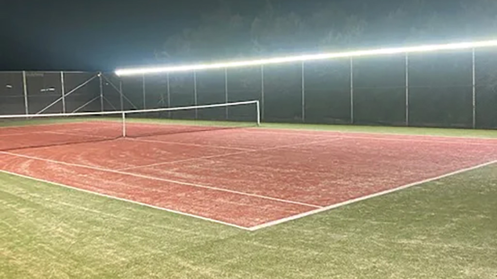 Obrázek LED reflektoru na sportovišti při západu slunce.